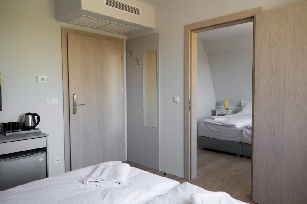 Rodzinny apartament blisko natury w Polanicy-Zdroju. Widok na przejściowy pokój i osobną sypialnię, idealny nocleg dla 4 osób.